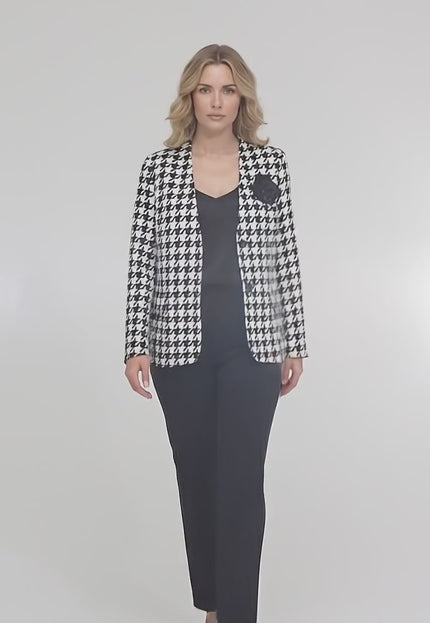 Студийно видео представяне на неутрален фон, в което макси модел върви бавно към камерата и носи Официално дамско сако в пепит с роза и подплата