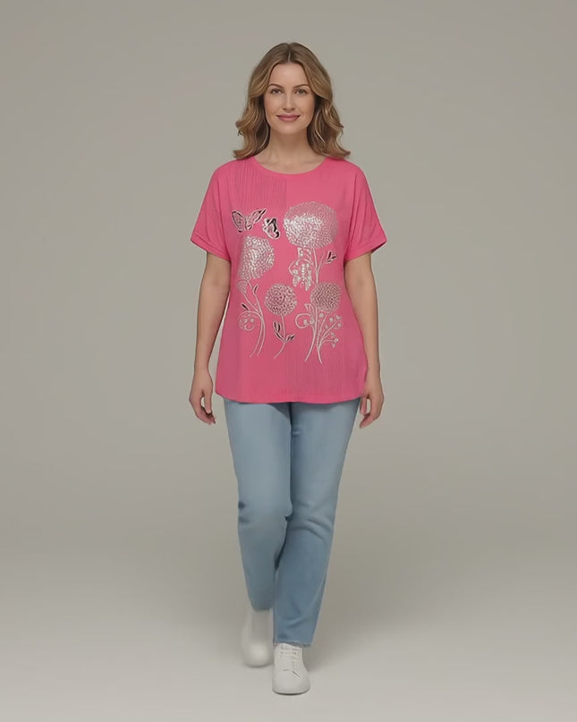 Видео представяне в студийна среда на неутрален фон, в което макси модел върви бавно към камерата, носейки Ежедневна лятна макси туника в цвят корал с красива флорална апликация