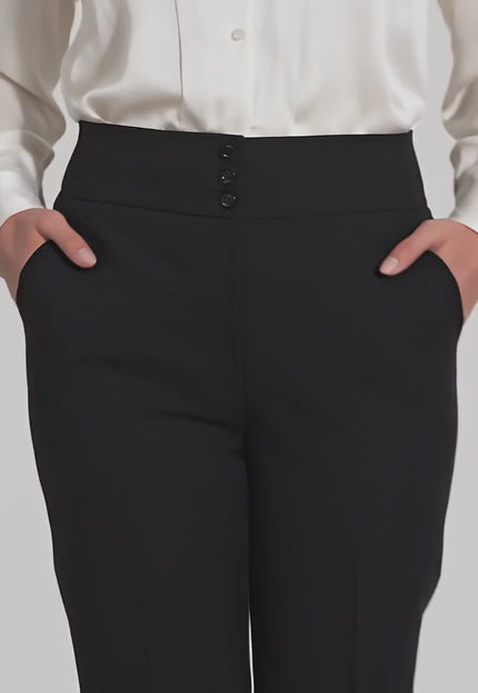 Видео на модел в студийна среда, който носи черен официален дамски панталон с ръб и копчета