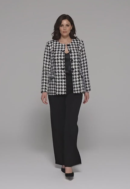 Студийно видео, в което плюс сайз модел върви бавно към камерата на неутрален фон, облечена в Официално дамско сако пепит в бяло големи размери