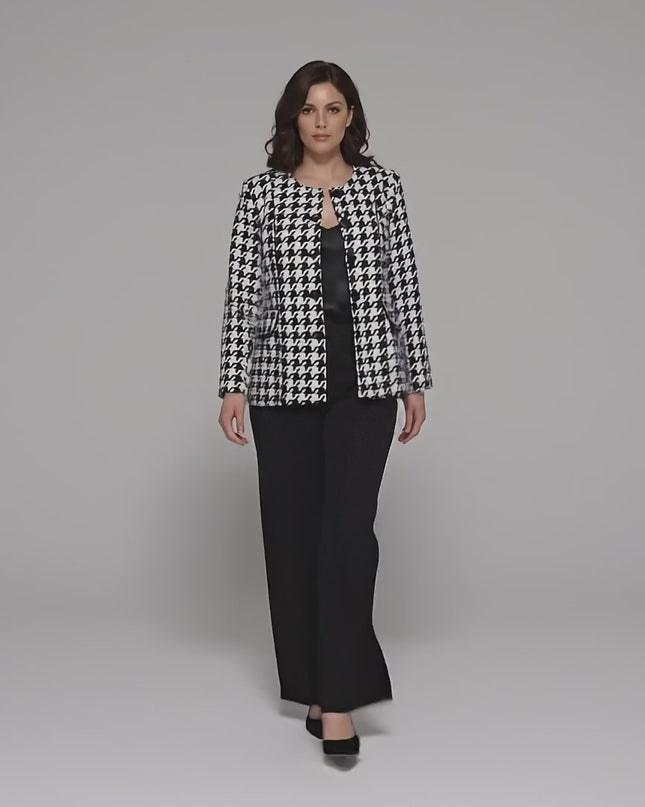 Студийно видео, в което плюс сайз модел върви бавно към камерата на неутрален фон, облечена в Официално дамско сако пепит в бяло големи размери