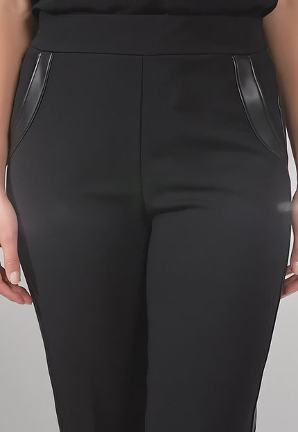 Видео представяне в студийна среда на неутрален фон, където plus-size модел върви бавно към камерата, облечена с Официален черен панталон с кант от еко кожа големи размери