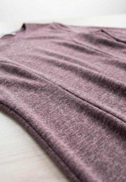 Детайлен кадър на разкроена рокля от плътна вискоза в цвят пепел от рози, показващ текстурата на материята и шевовете в горната част.