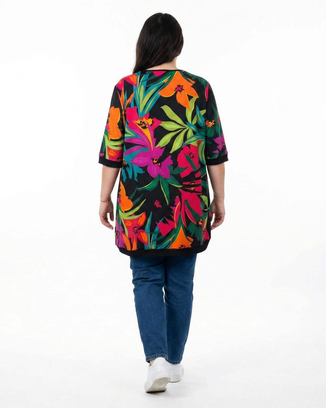 Шарена лятна туника големи размери с едър тропически флорален принт. Изглед отзад на модела, заснет в цял ръст на бял фон.