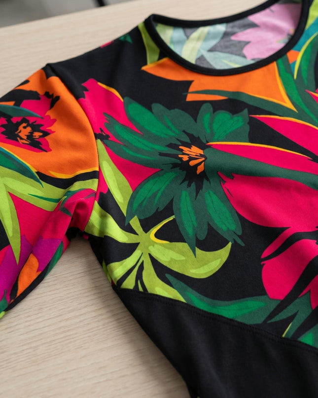Детайл отблизо на шарена лятна туника големи размери, показващ едър тропически флорален принт, обло деколте и ръкав.