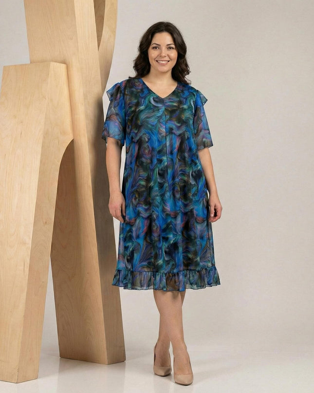 Шарена официална рокля големи размери с ефектен ръкав и шифон, V-образно деколте и абстрактен принт в синьо, заснета в цял ръст.