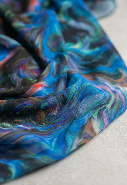 Детайл отблизо на фината материя на шарена официална рокля големи размери, показващ пъстър шифон с абстрактен десен в наситено синьо.