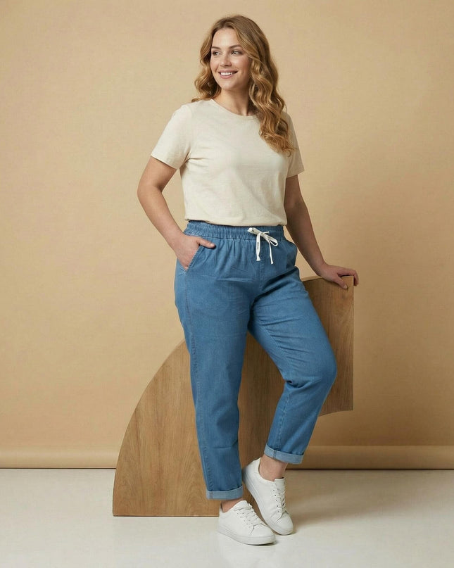 Сини летни дънки големи размери в цял ръст. Моделът демонстрира правата кройка, удобния ластик с бели връзки на талията и стилно навитите крачоли.