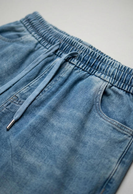 Детайл отблизо на талията на сини макси дамски дънки, показващ еластичния колан с връзки и текстурата на материята от тенсел и памук.