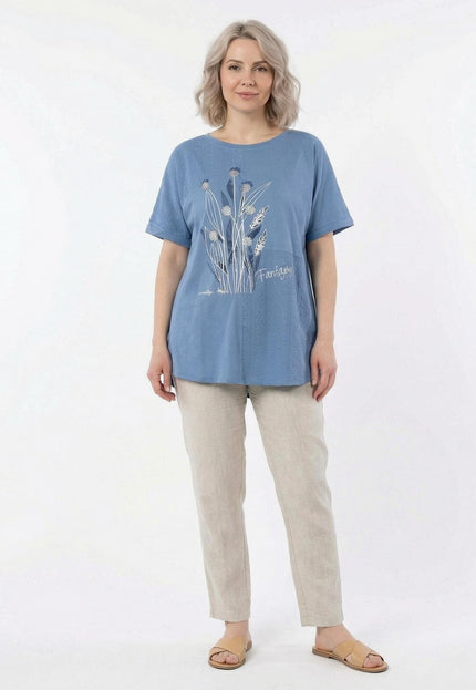 Синя лятна туника големи размери с красива флорална апликация и къси ръкави, представена в цял ръст на бял фон.