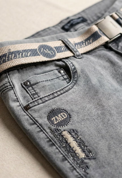 Детайл отблизо на сиви ежедневни макси дънки с ластик, преден джоб, текстилен колан с катарама и емблема с лого ZMD.