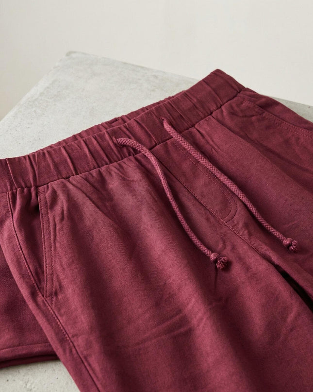 Детайлен кадър на талията на спортно-елегантен макси панталон в цвят бордо, показващ еластичния колан с връзки и страничните джобове.