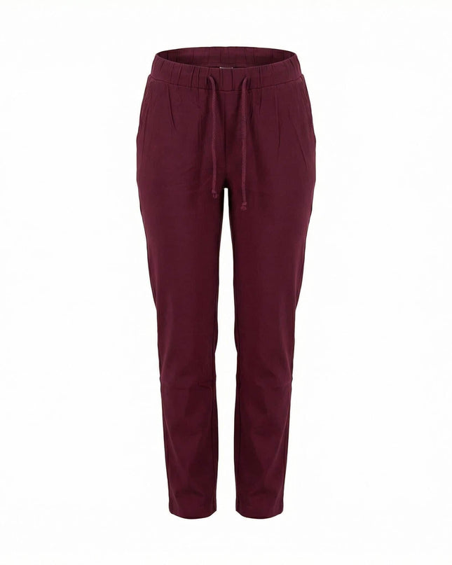 Спортно-елегантен макси панталон в цвят бордо с прав крачол. Преден изглед на дрехата на бял фон, детайлно показващ ластичната талия с връзки и джобовете.