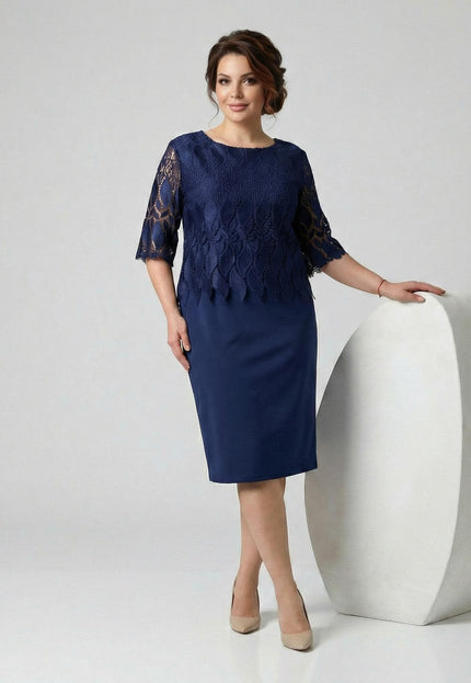 Тъмносиня официална макси рокля с горна част от дантела и ръкави до лакътя, заснета върху модел в цял ръст до бял декор.