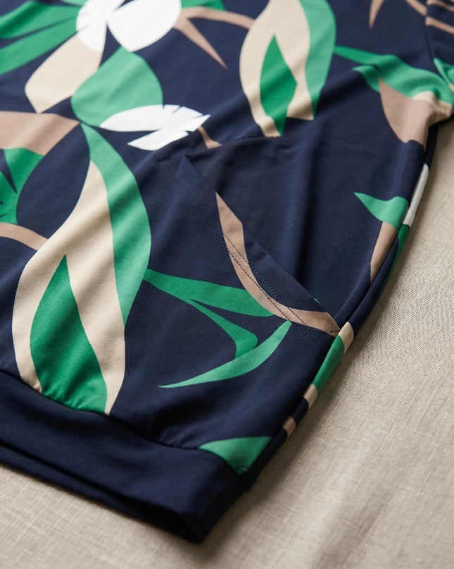 Детайл отблизо на тъмносиня лятна туника големи размери, показващ красивия принт на листа в зелено и бежово, както и практичния преден джоб.